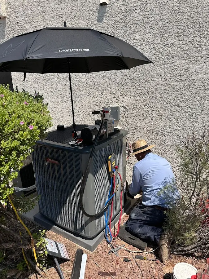 HVAC technician performing outdoor AC maintenance in East Aurora